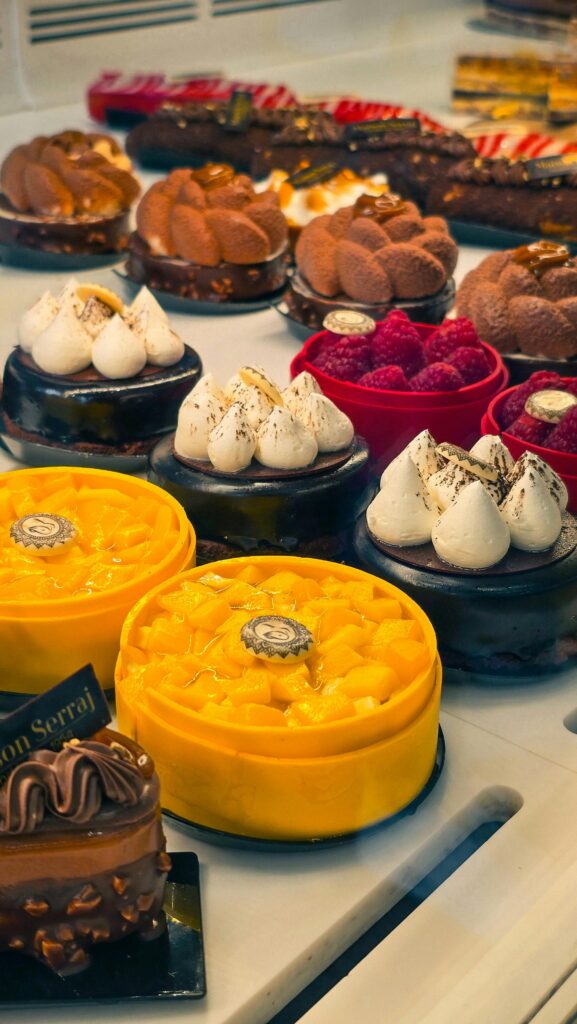 Delicious variety of gourmet cakes including chocolate and mango flavors in a bakery display.